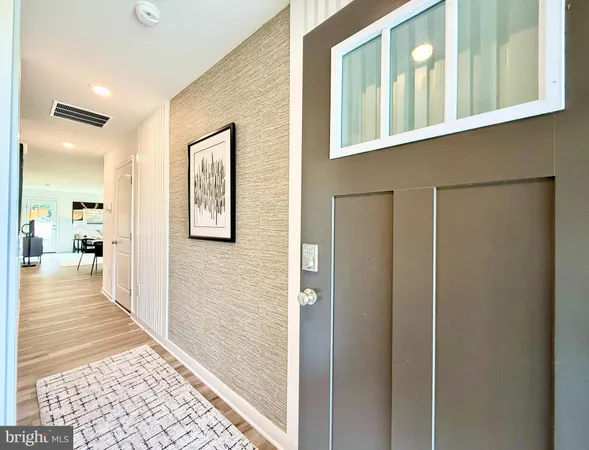 a view of a hallway with a window and wooden floor