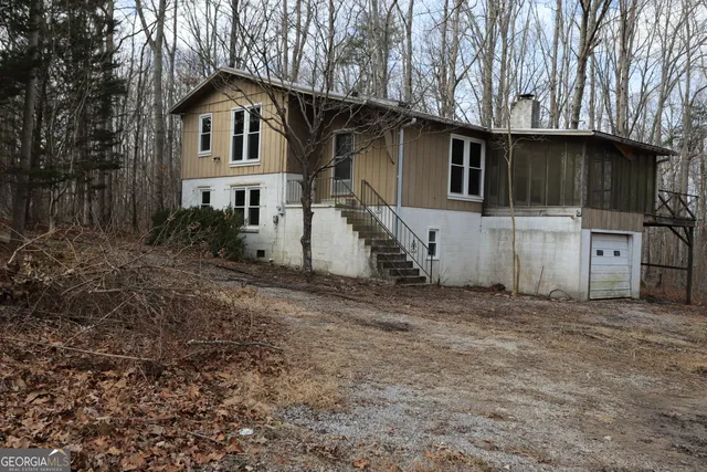 a view of a grey house with a yard