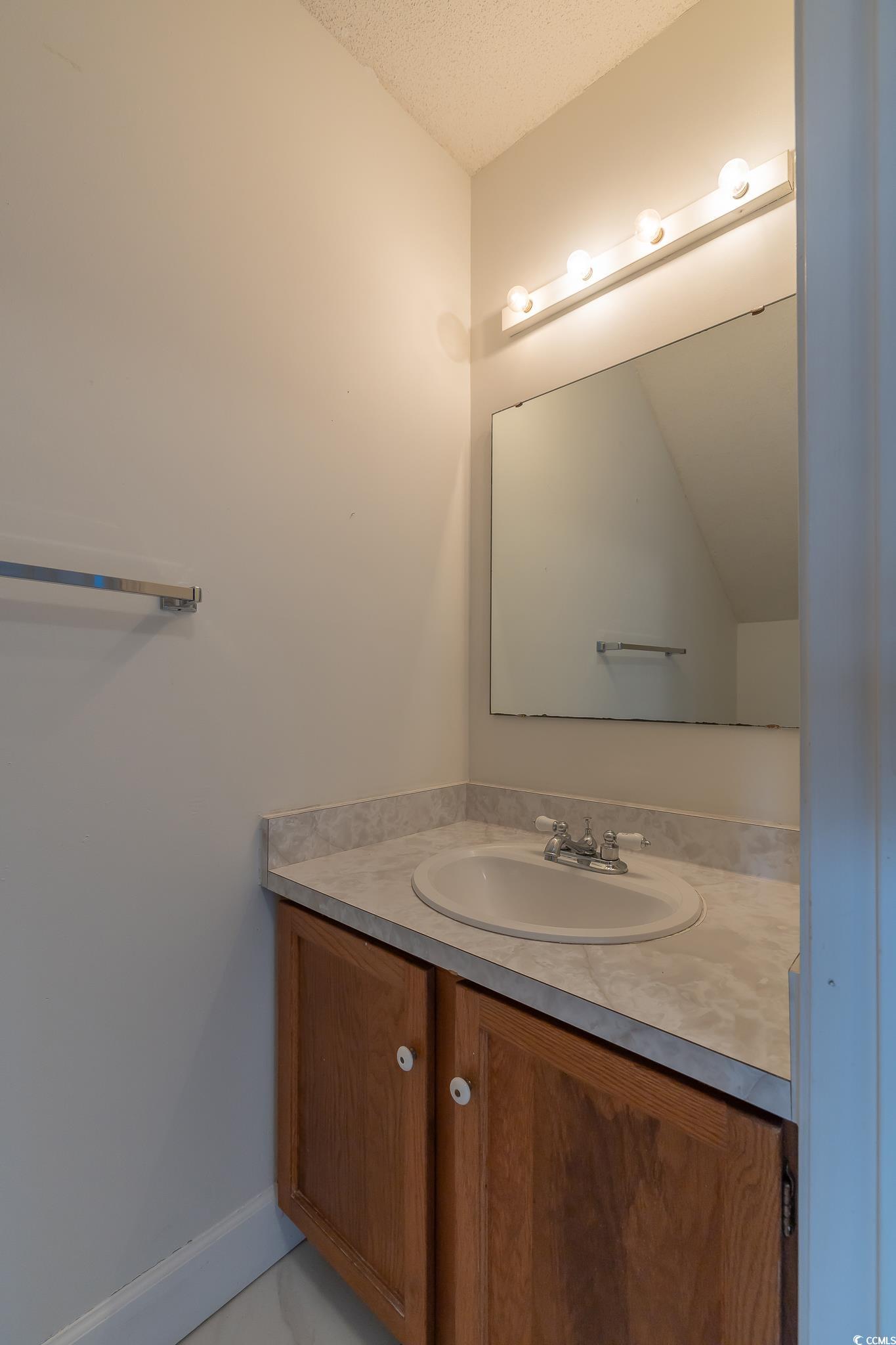 43 Pheasant Loop, Unit 302 Georgetown, SC 29440 - Photo 15 of 38 Bathroom featuring vanity and a textured ceiling