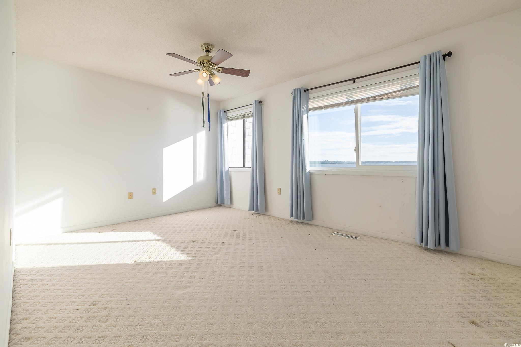 43 Pheasant Loop, Unit 302 Georgetown, SC 29440 - Photo 19 of 38 Carpeted spare room with a ceiling fan and a textured ceiling