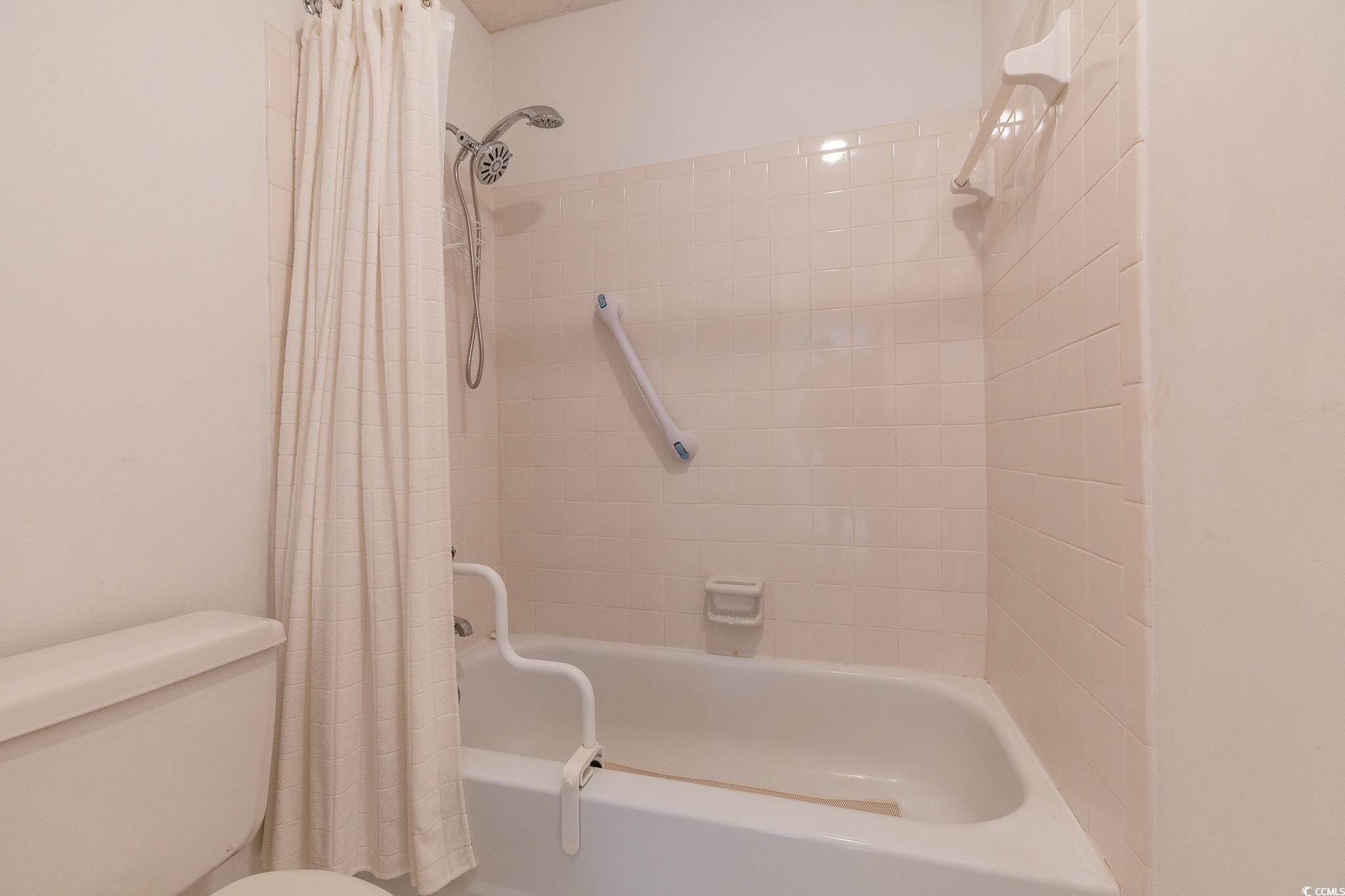 43 Pheasant Loop, Unit 302 Georgetown, SC 29440 - Photo 20 of 38 Full bathroom featuring toilet and shower / bath combination with curtain