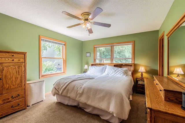a bedroom with a bed a window and a flat screen television