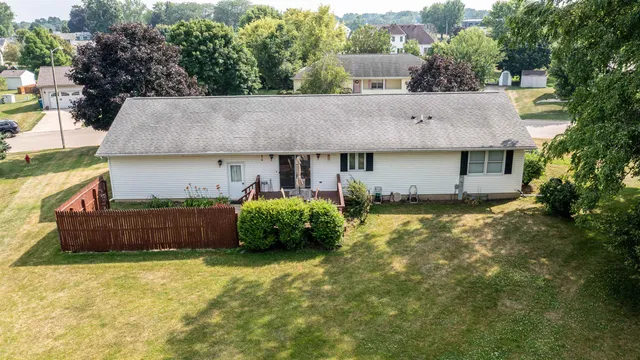 a front view of house with yard and trees in the background