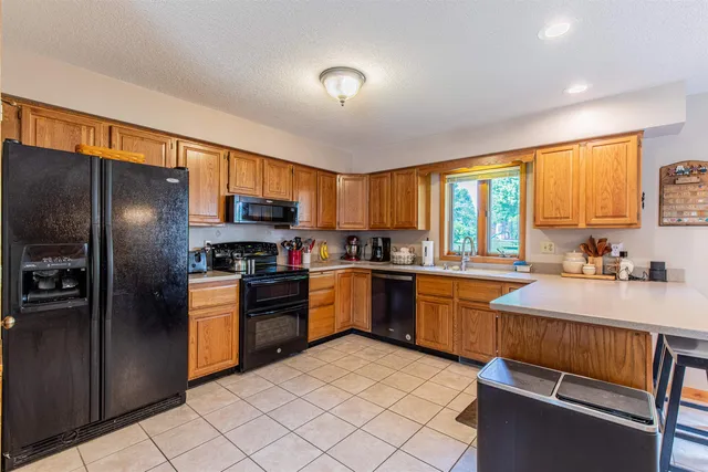 a kitchen with granite countertop stainless steel appliances a stove sink and refrigerator