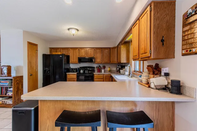 a kitchen with a refrigerator a stove a sink a counter space and cabinets