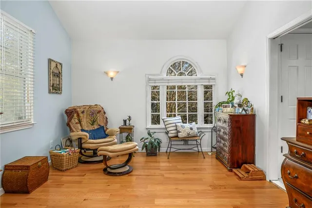 a view of a white house next to a yard with plants and trees