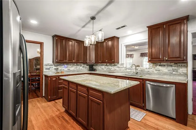 a kitchen with stainless steel appliances granite countertop a sink stove and refrigerator