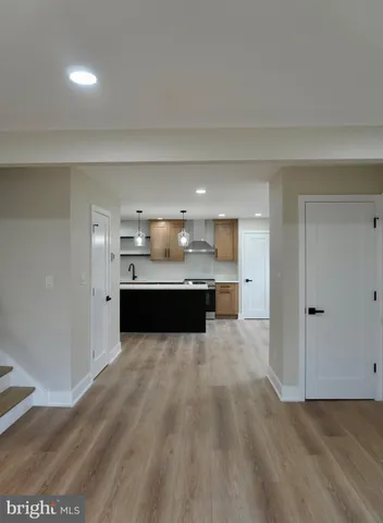 a living room with wooden floor and white walls