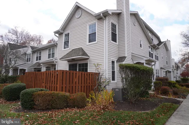a view of a house with a yard and wooden fence