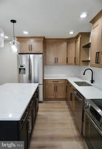 a kitchen with stainless steel appliances granite countertop a sink a stove and a refrigerator