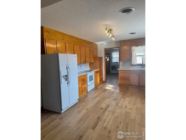 a kitchen with cabinets and wooden floor
