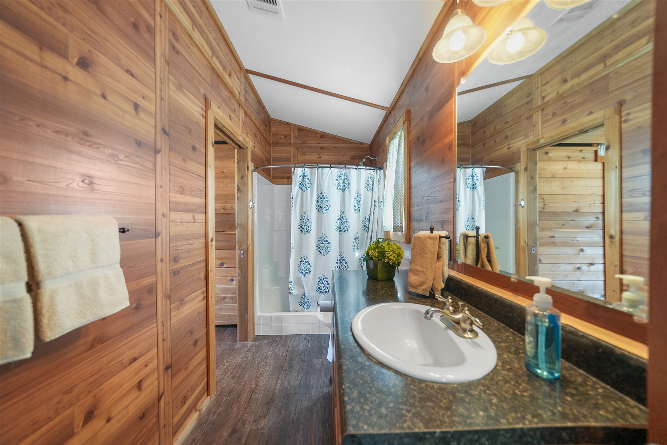 26250 A Riley Road Waller, TX 77484 - Photo 49 of 50 Cabin ensuite bath with cedar-lined walls, spacious vanity, and full tub/shower; served by a tankless electric water heater.