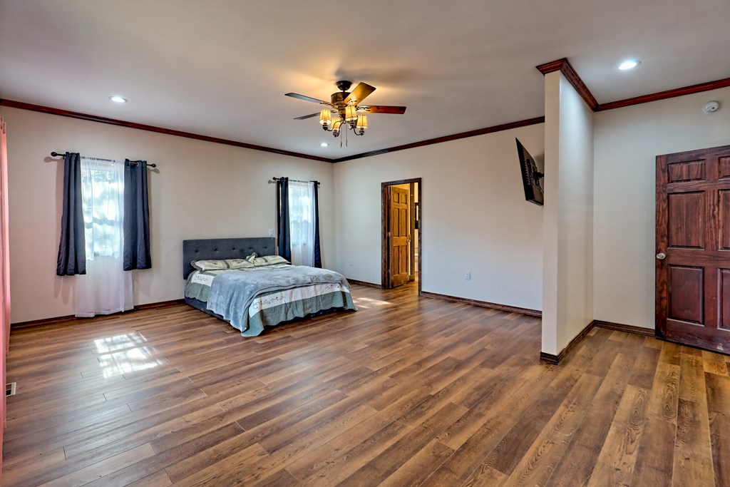 87 Mason Lane Marble, NC 28905 - Photo 27 of 66 a spacious bedroom with a bed and a chandelier