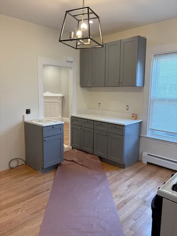 a room with kitchen island sink and wooden cabinets