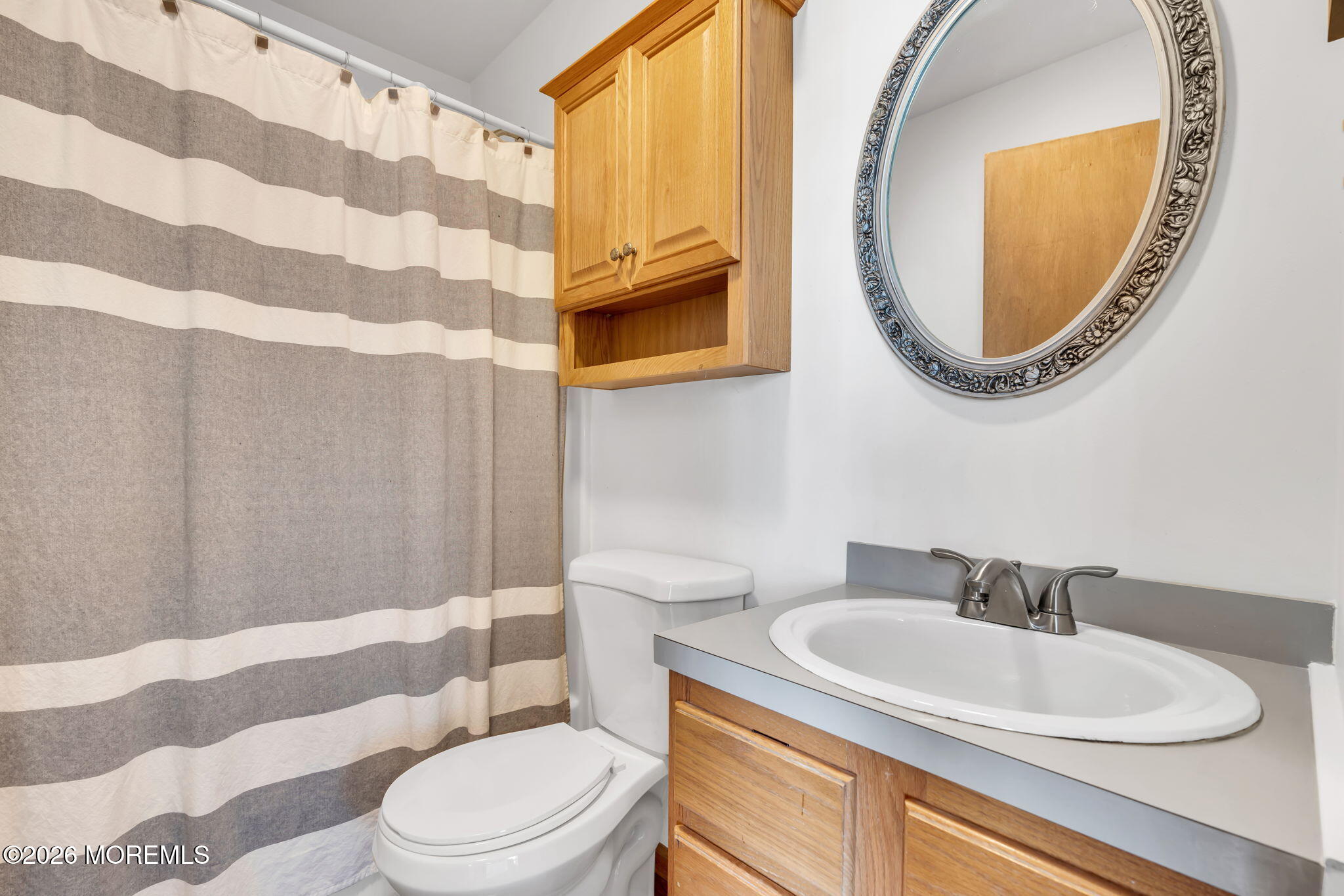 1706 Bay Avenue Point Pleasant, NJ 08742 - Photo 18 of 34 a bathroom with a sink a mirror a toilet and a mirror