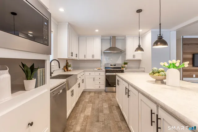 a kitchen with kitchen island granite countertop a sink a counter space appliances and cabinets