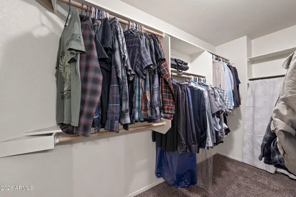 a view of walk in closet with clothes