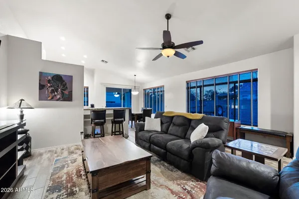 a living room with furniture a ceiling fan and a flat screen tv