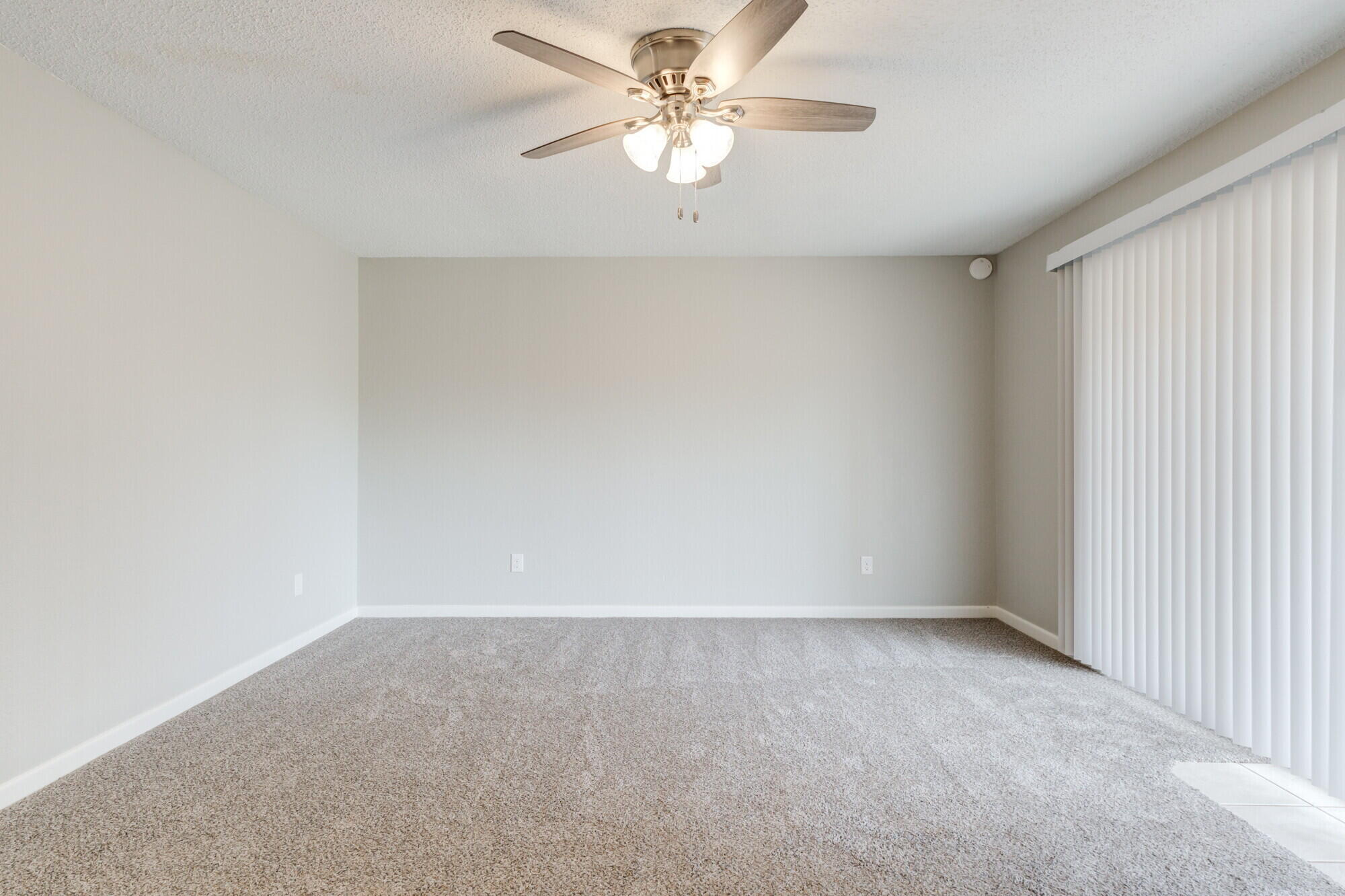 4916 46th Street Lubbock, TX 79414 - Photo 11 of 31 an empty room with a chandelier fan and windows