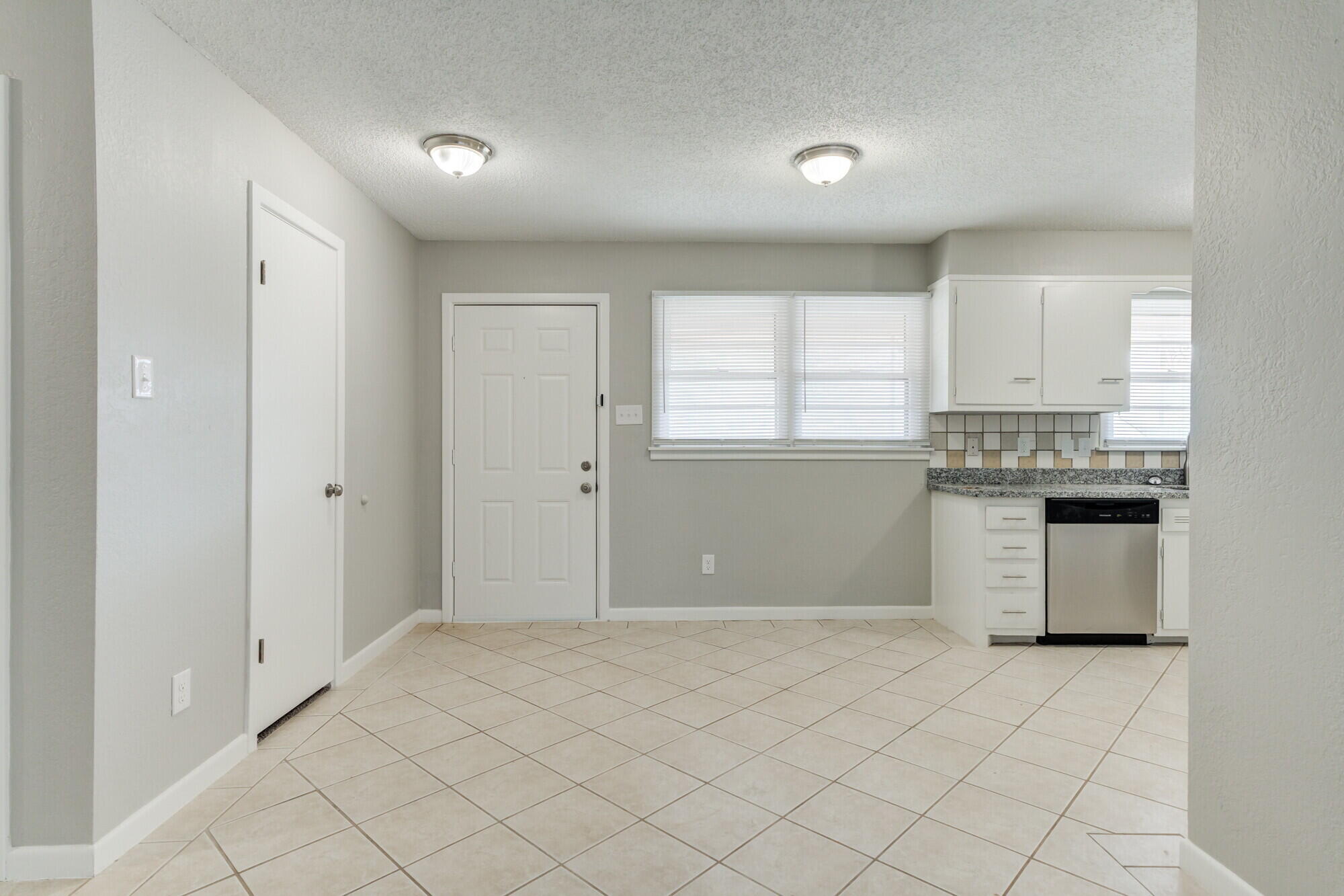4916 46th Street Lubbock, TX 79414 - Photo 14 of 31 a kitchen with a stove a refrigerator and white cabinets