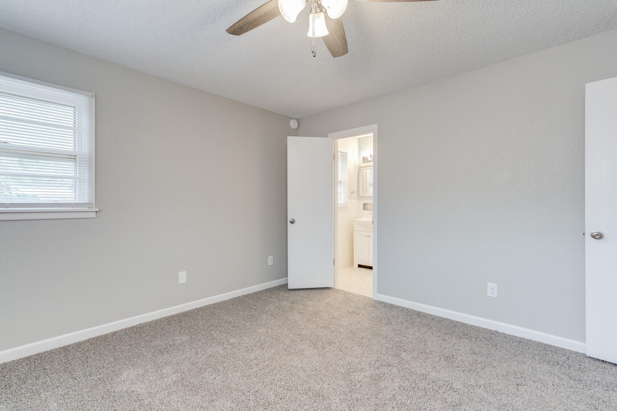 4916 46th Street Lubbock, TX 79414 - Photo 17 of 31 an empty room with a chandelier fan and windows