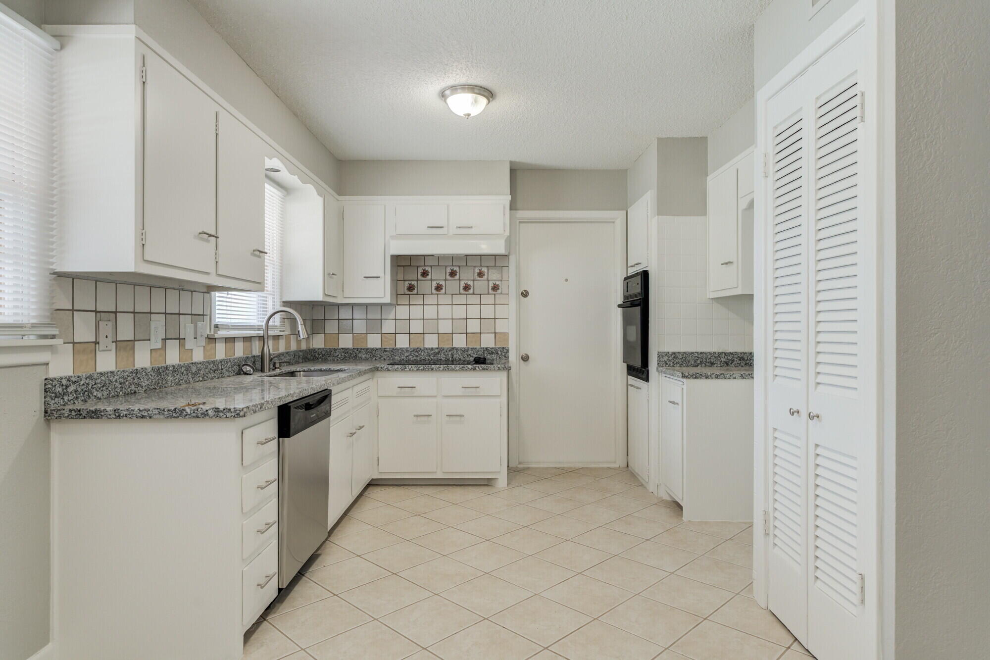 4916 46th Street Lubbock, TX 79414 - Photo 4 of 31 a kitchen with white cabinets and appliances