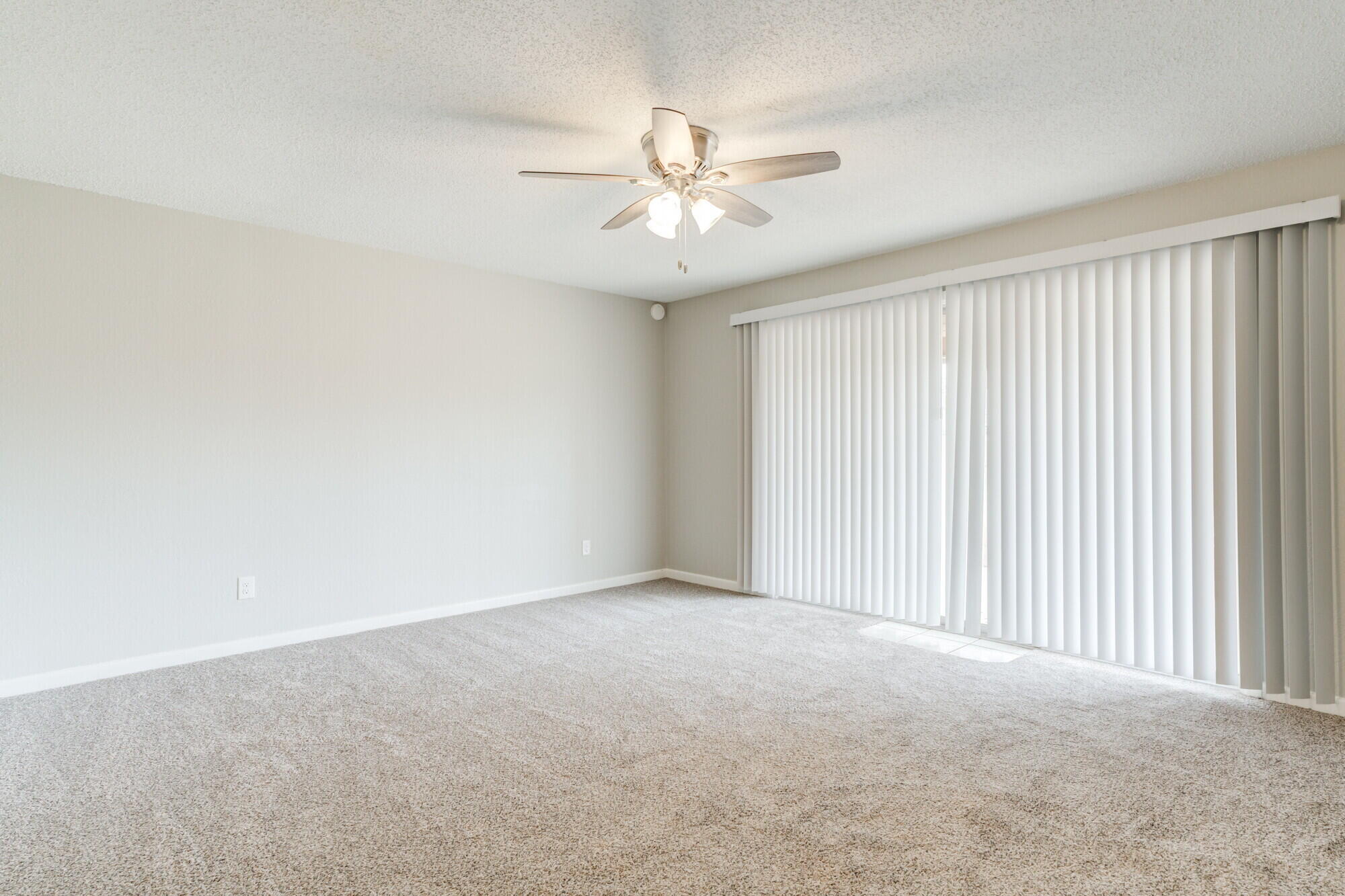 4916 46th Street Lubbock, TX 79414 - Photo 10 of 31 an empty room with a chandelier fan and windows