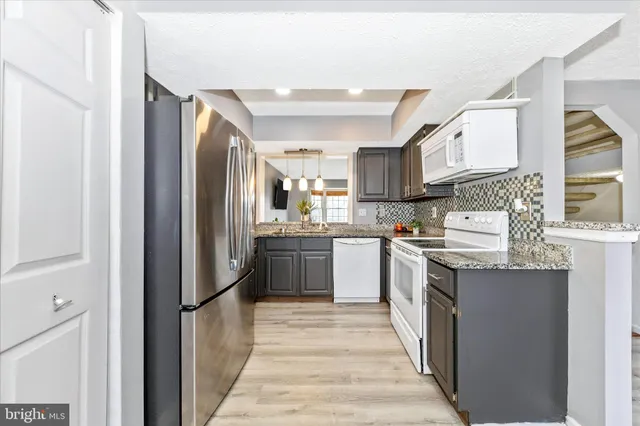 a kitchen with stainless steel appliances granite countertop a refrigerator and a stove