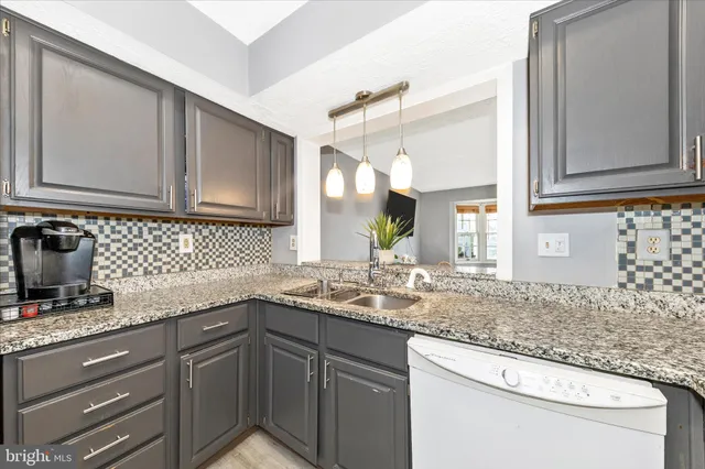 a kitchen with granite countertop a sink and cabinets