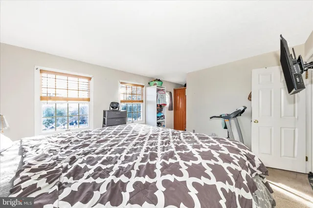 a bedroom with a large bed and a flat tv screen on dresser