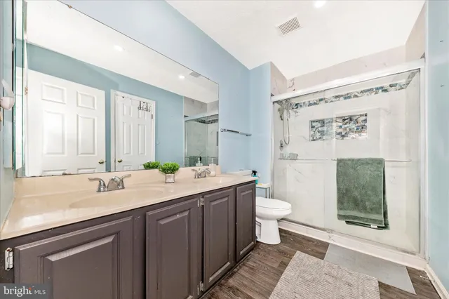 a bathroom with a granite countertop sink mirror vanity and toilet
