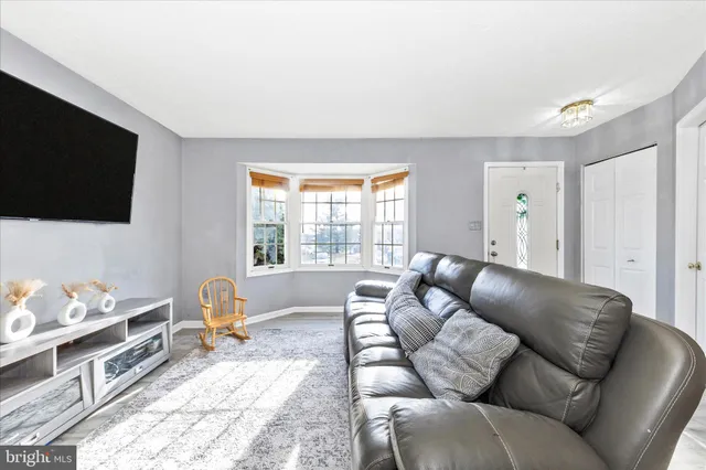 a living room with furniture a flat screen tv and a window