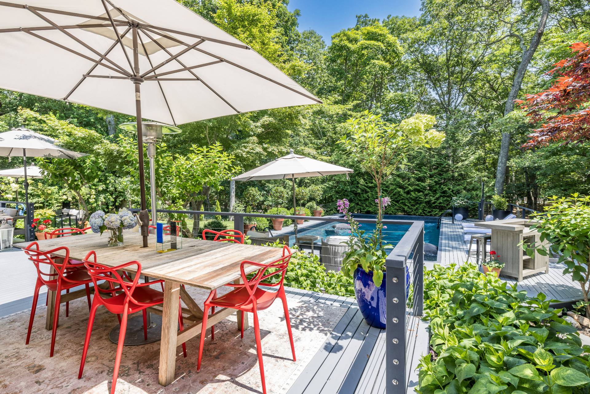 64 Alewife Brook Road East Hampton, NY 11937 - Photo 6 of 26 a view of a patio with chairs and table under an umbrella with a barbeque