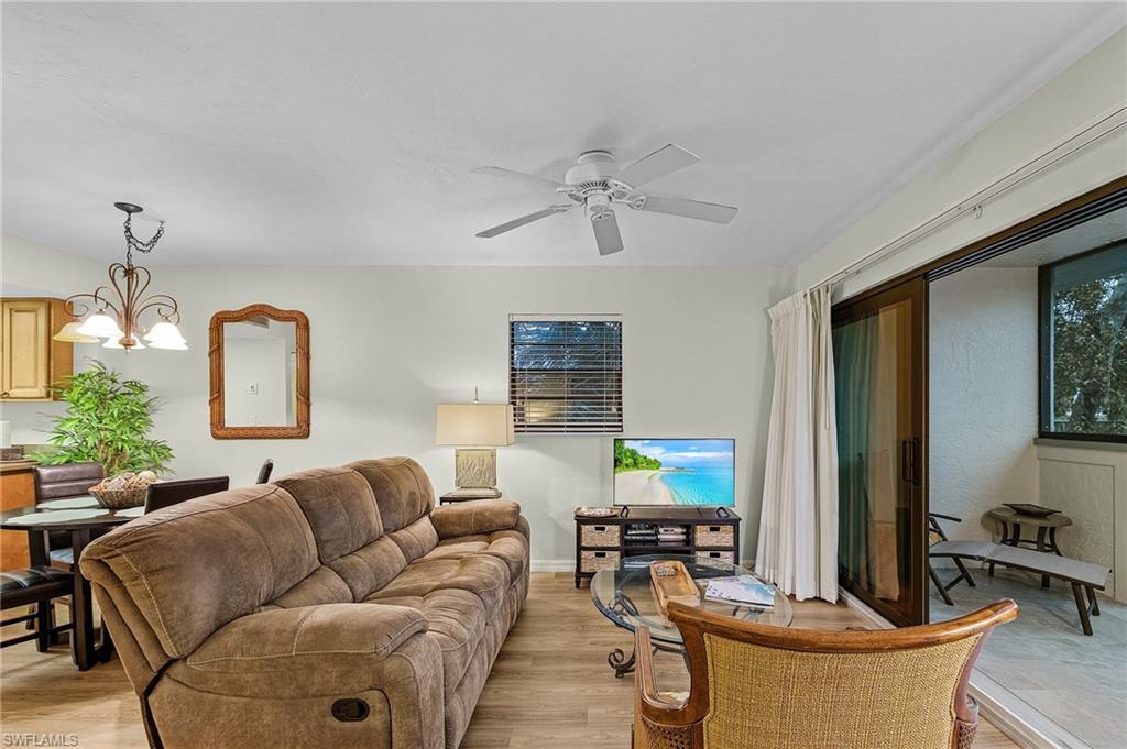 600 Neapolitan Way, Unit 349 Naples, FL 34103 - Photo 11 of 34 a living room with fireplace furniture and a chandelier