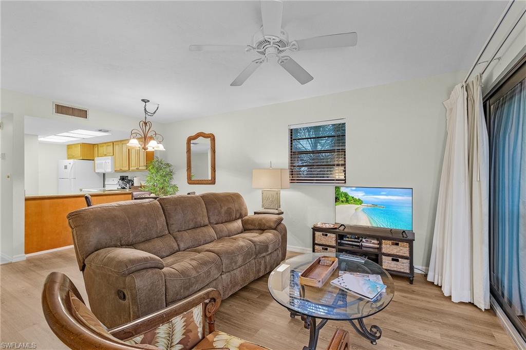 600 Neapolitan Way, Unit 349 Naples, FL 34103 - Photo 12 of 34 a living room with furniture a dining table and a fireplace