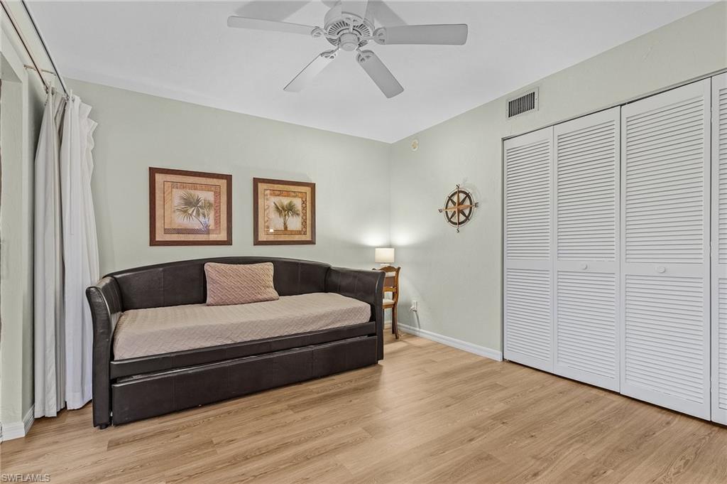 600 Neapolitan Way, Unit 349 Naples, FL 34103 - Photo 14 of 34 a bedroom with a bed and a chandelier