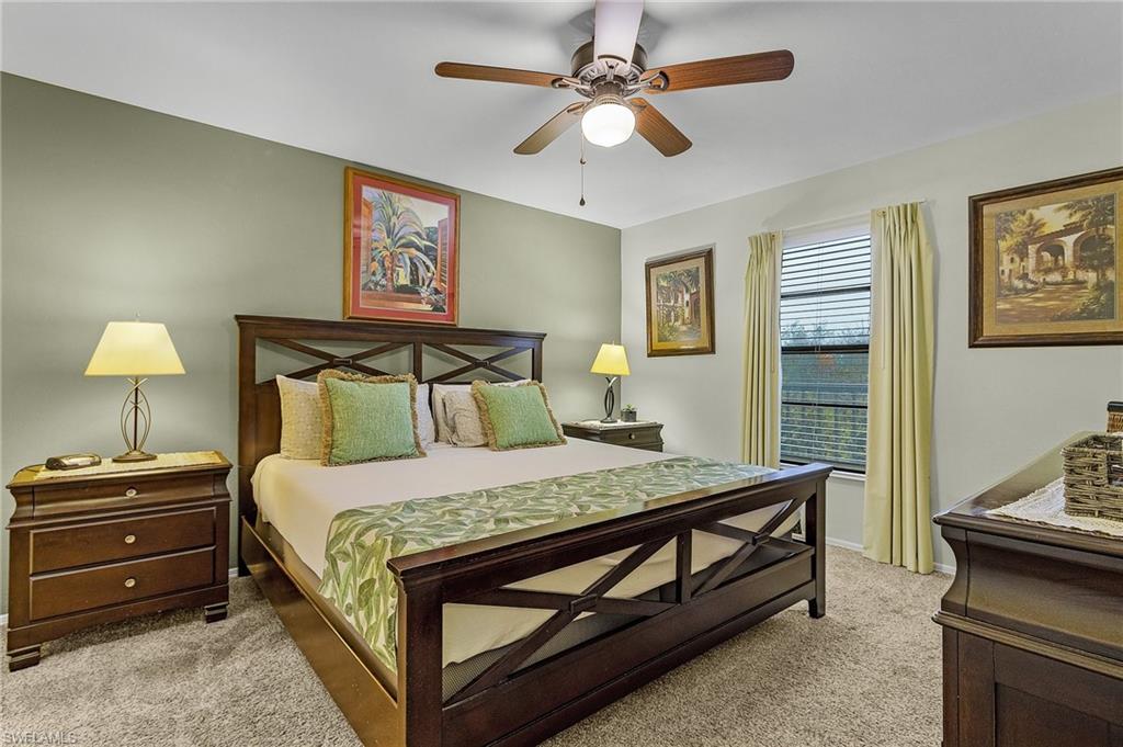 600 Neapolitan Way, Unit 349 Naples, FL 34103 - Photo 18 of 34 a bedroom with a bed and a chandelier