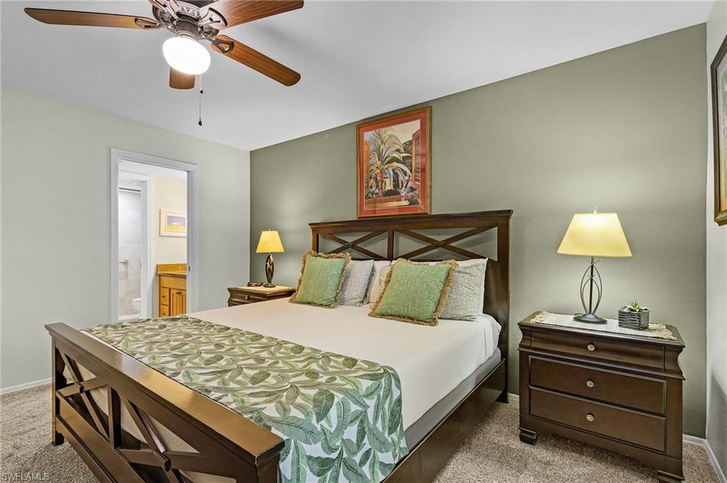 600 Neapolitan Way, Unit 349 Naples, FL 34103 - Photo 19 of 34 a bedroom with a bed and a chandelier