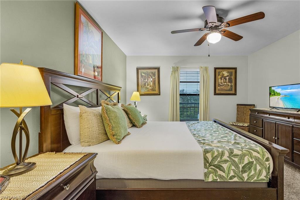 600 Neapolitan Way, Unit 349 Naples, FL 34103 - Photo 20 of 34 a bedroom with a bed and a chandelier