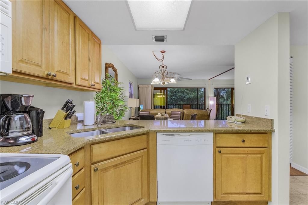 600 Neapolitan Way, Unit 349 Naples, FL 34103 - Photo 7 of 34 a kitchen with a sink and cabinets