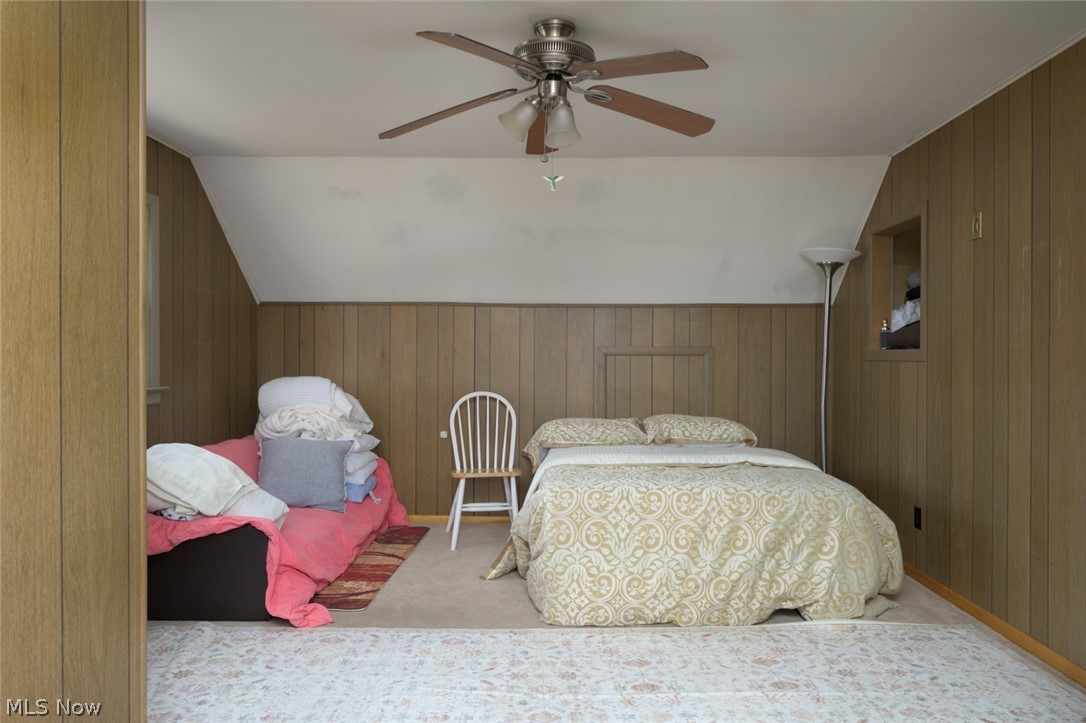1165 Hampton Road Kent, OH 44240 - Photo 28 of 39 Carpeted bedroom featuring wooden walls, lofted ceiling, a ceiling fan, and wainscoting