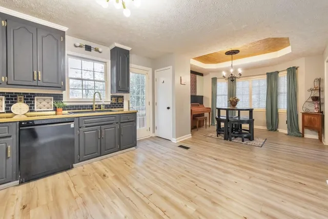 a kitchen with stainless steel appliances granite countertop a sink a stove a refrigerator with grey cabinets