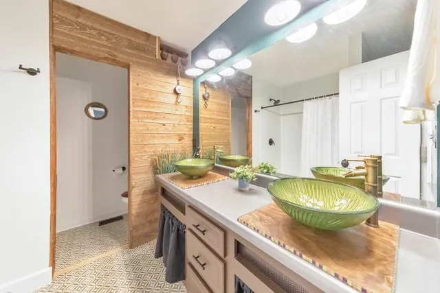 a bathroom with a granite countertop sink and a mirror