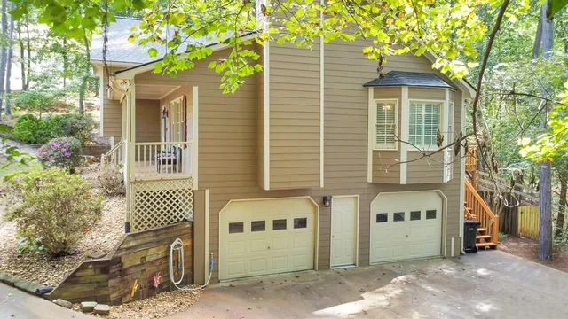 an aerial view of a house with a yard and trees all around