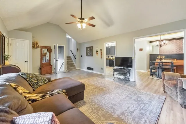 a kitchen with stainless steel appliances kitchen island granite countertop a table chairs sink and cabinets