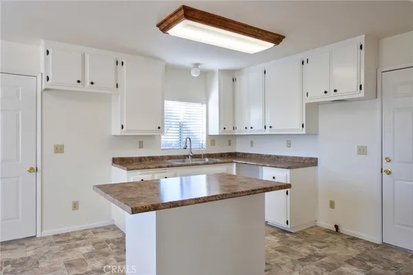 a kitchen with granite countertop a sink stove and cabinets