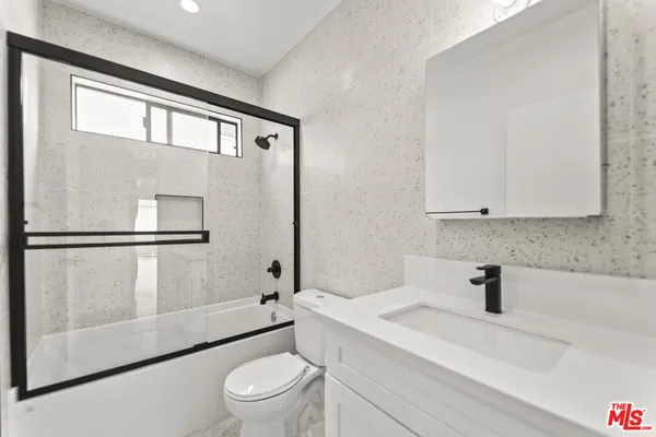 a bathroom with a sink a toilet and a shower