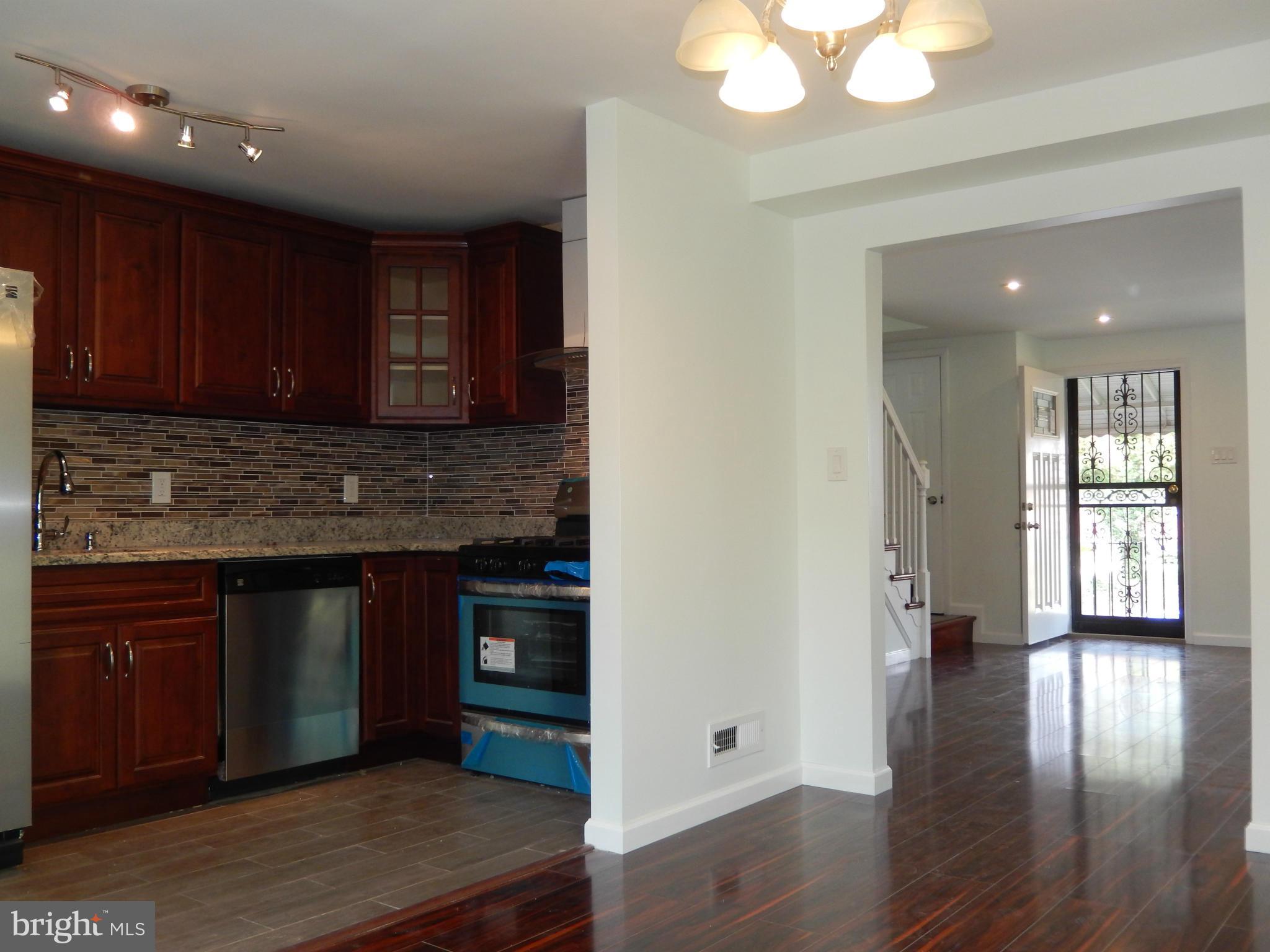 4301 Cedar Garden Road Baltimore, MD 21229 - Photo 17 of 29 a kitchen with granite countertop wooden cabinets and white appliances