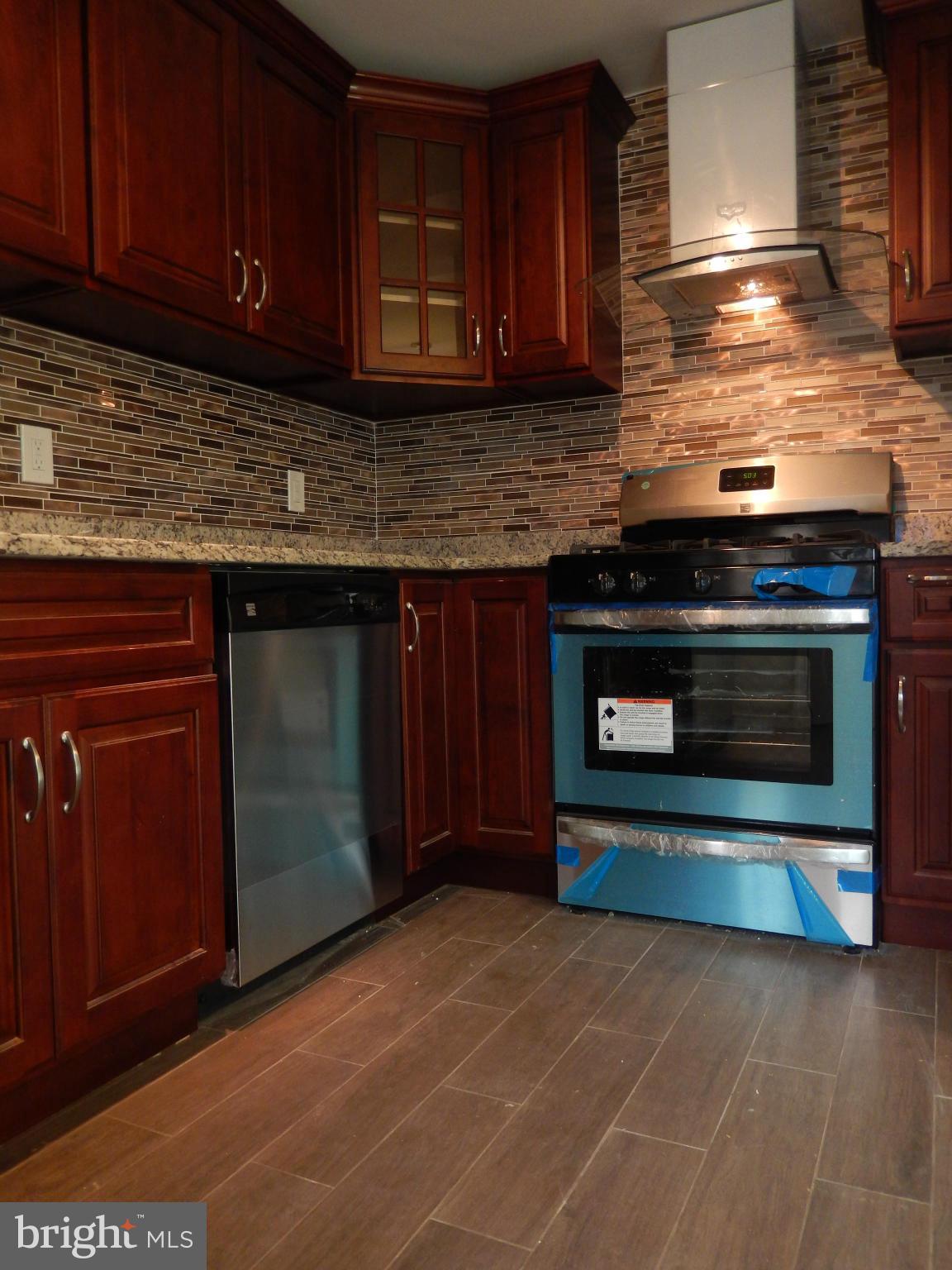 4301 Cedar Garden Road Baltimore, MD 21229 - Photo 18 of 29 a kitchen with granite countertop a stove top oven microwave and cabinets