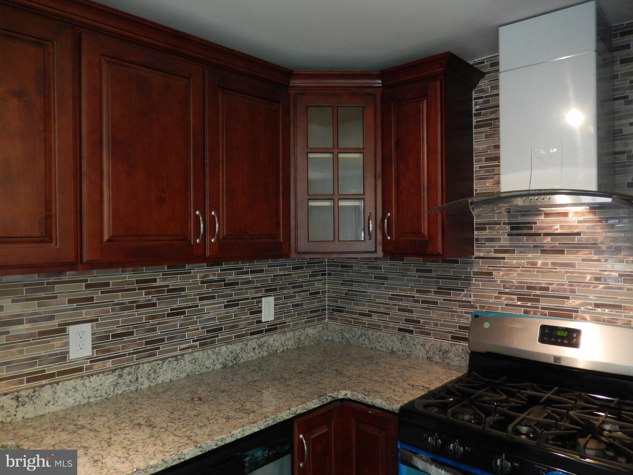 4301 Cedar Garden Road Baltimore, MD 21229 - Photo 20 of 29 a kitchen with granite countertop cabinets and stove top oven
